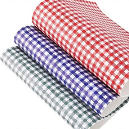 Three sheets of gingham leatherette in red, blue, and green colors, stacked on top of each other.