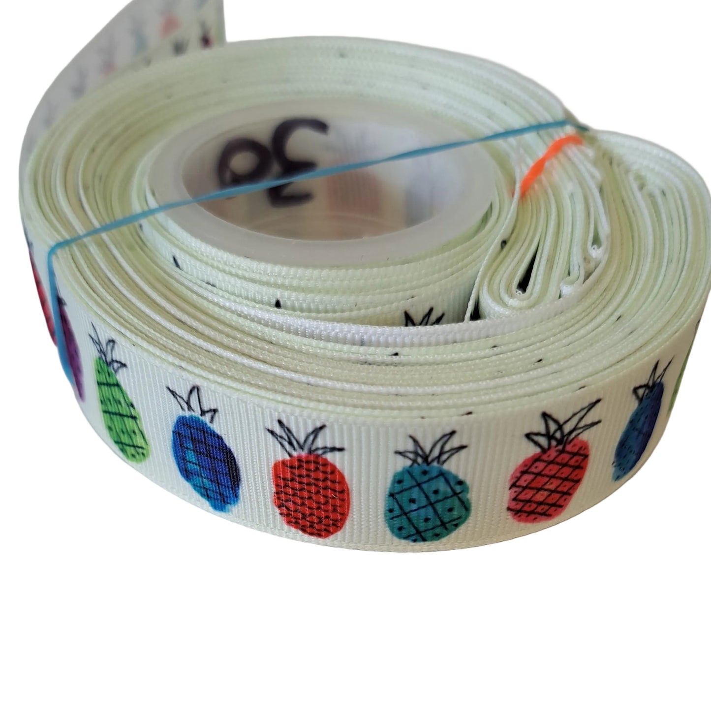 Roll of colorful ribbon with fruit patterns on a white background. Pineapples 