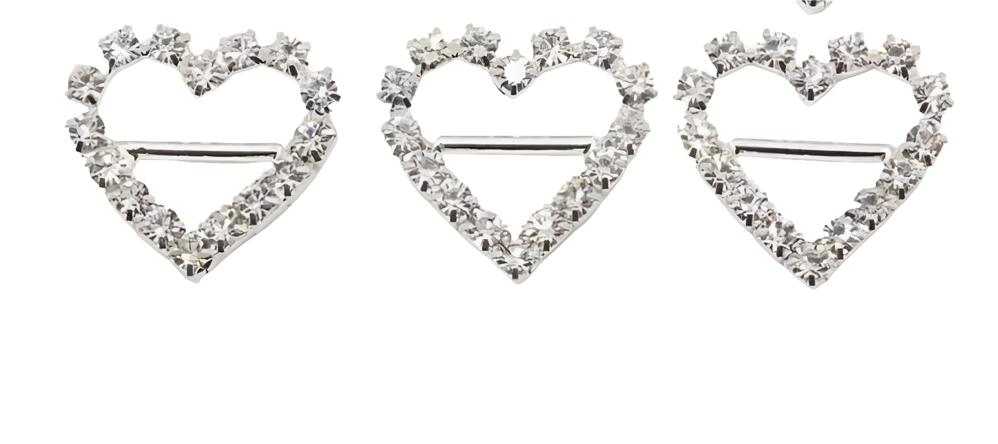 three heart-shaped brooches with diamond-like stones on a white background