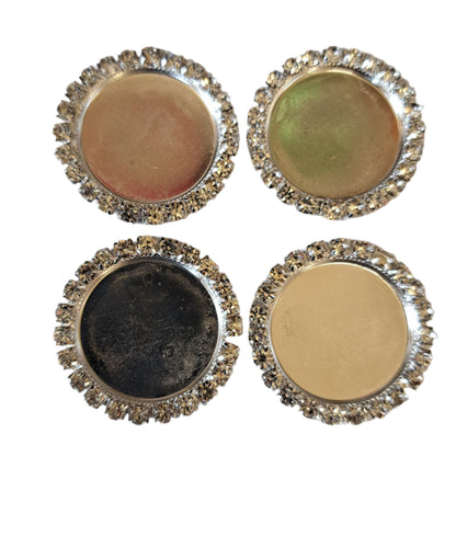 four round bling bottle caps in gold colour on a white background