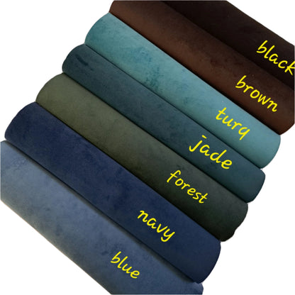 seven rolls of coloured suede fabric on a white background