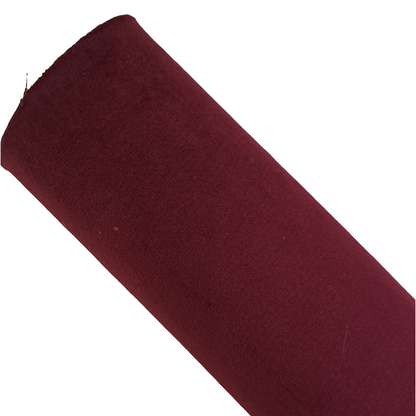 a roll of burgundy coloured velvet fabric roll on a white background