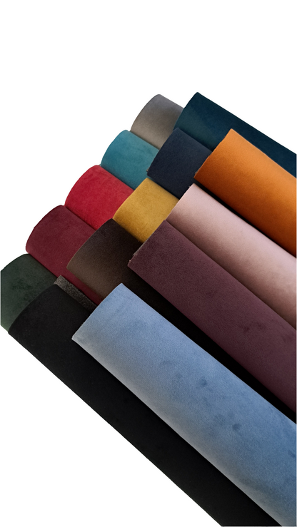 fourteen rolls coloured velvet fabric on a white background
